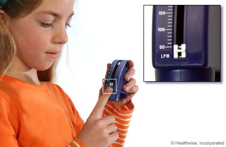 A child setting a peak flow meter to its lowest number.