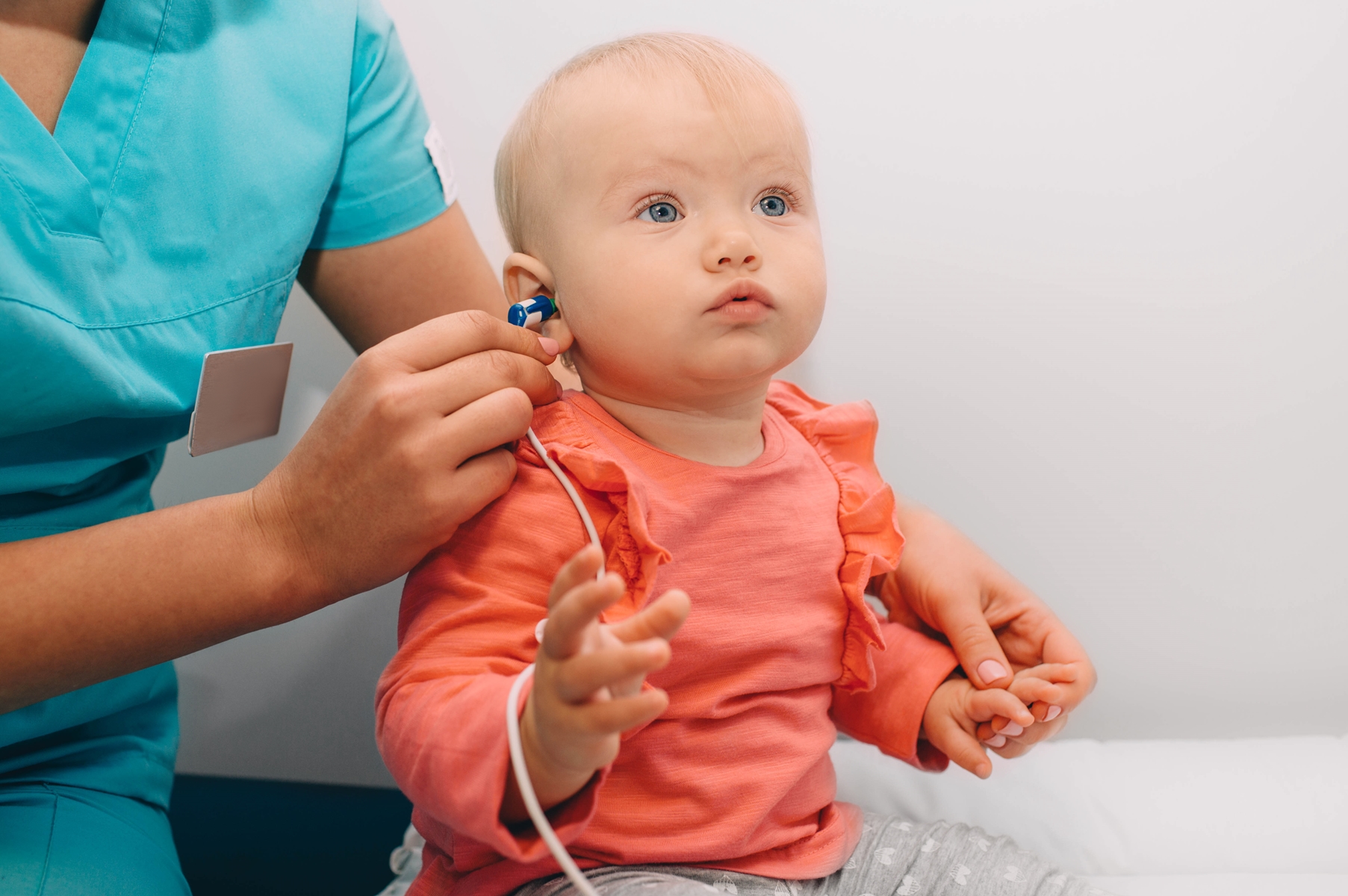 Healthcare professional puts soft probe in baby's ear
