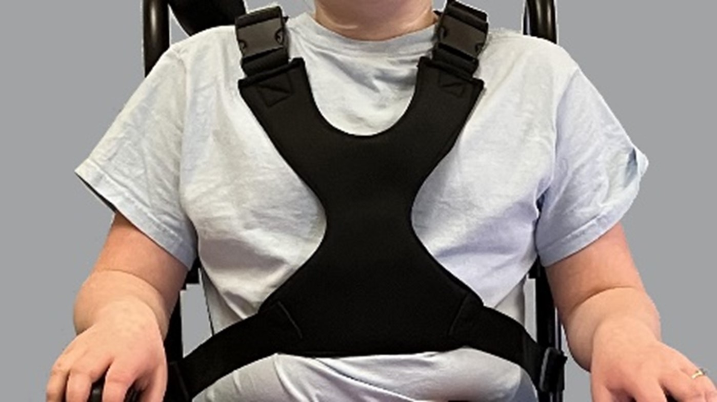 child in wheelchair with chest harness