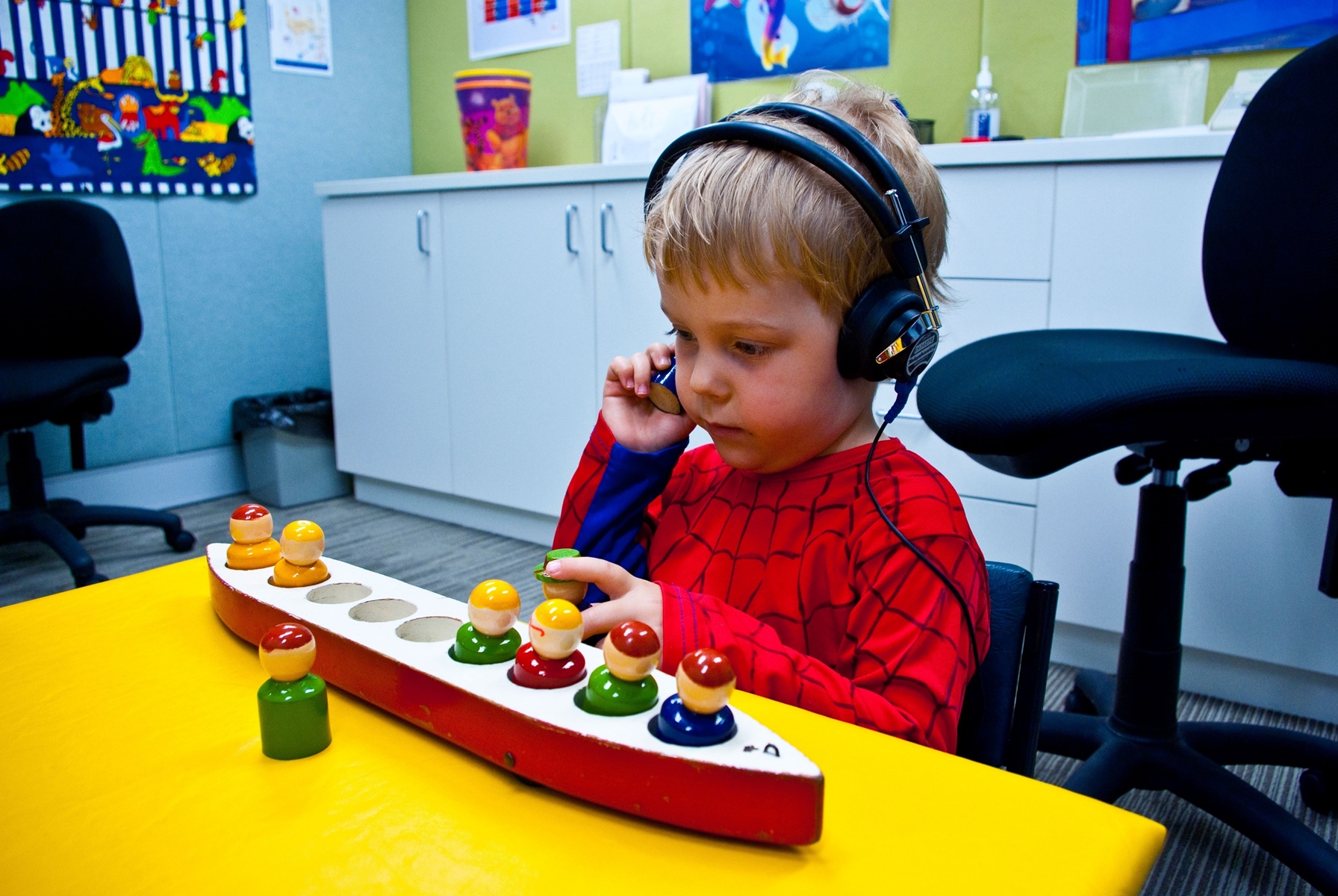 Child wearing headphones and holding a toy