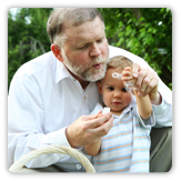 A grandfather blowing bubbles with grandson