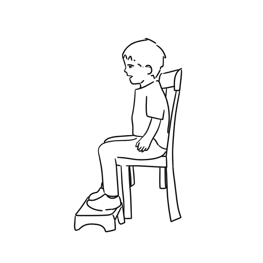 child in chair with feet on block