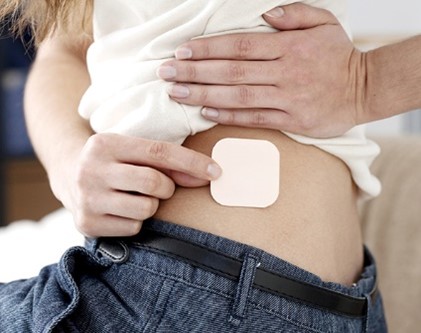 person putting on birth control patch