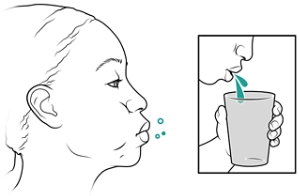 Person swishing water in mouth and then spitting into cup.