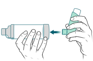 Mouthpiece of inhaler being placed into spacer.