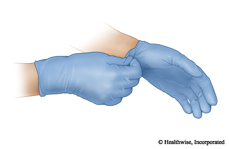 Use one hand to grab the cuff of the other glove.
