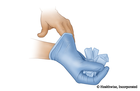 Ball up the glove with your covered hand and then put one or two bare fingers inside the second glove so you can remove it.