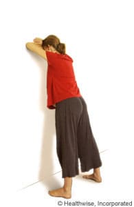 Person leaning forward against a wall. Person leaning forward against a wall.