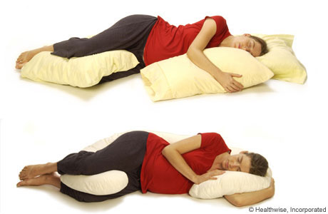 Person lying on their side and supported by pillows. Person lying on their side and supported by pillows.